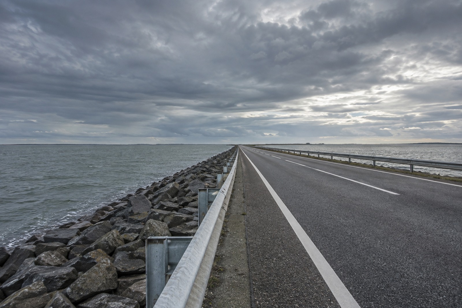 Rechte weg over een dam tussen de Noordzee en een binnenmeer